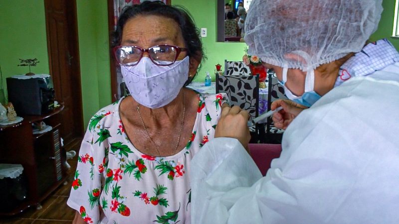 Maria de Nazaré Magalhães, de 88 anos, recebendo a primeira dose da vacina CoronaVac. 